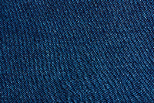 Dark blue jeans texture close up with horizontal thread lines